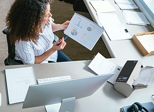 une femme scannant des documents sur un scanner Ricoh fi-8190 au bureau